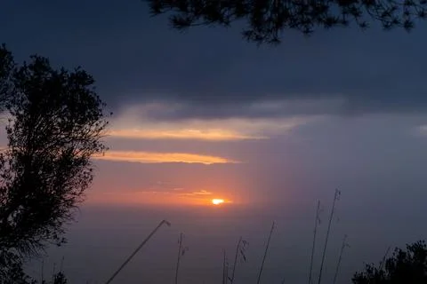 Sunset view in calm sea surface. Idyllic orange sundown above the clouds Stock Photos
