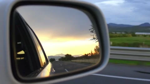 Sunset view in car side mirror, Driving on highway during golden hour road trip Stock Footage 339590878