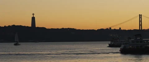 Sunset view of a city coast with a ship and a bridge in the background Stock Footage 147570607