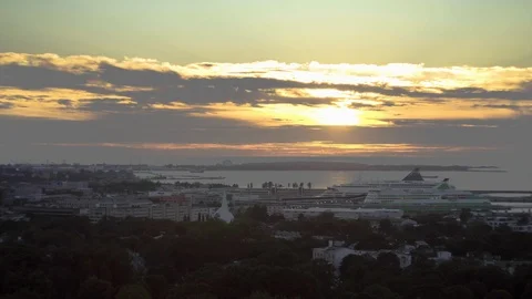 Sunset view on city harbor. Two cruise ships docked. Sun hid behind clouds. Video stock 92060654