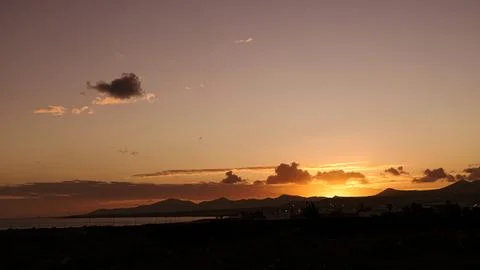 Sunset view with clouds, horizon with silhouettes of mountains Stock Photos