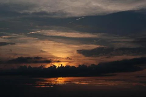 Sunset - view of cloudy sky and setting sun Stock Photos