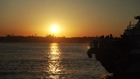 Sunset View of Ferry Docking at Istanbul's Waterfront with Silhouetted Stock Footage 278732921
