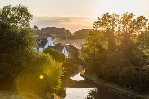Sunset view flying midges over British rural landscape scene with river near Photos