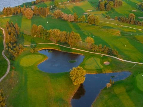 Sunset View of a Golf Course with Fairways, Bunkers, and Water Hazards Stock Photos