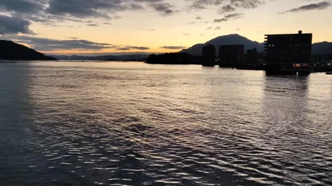 Sunset view of Hiroshima from a ferry with night city landscape, Japan. Stock Footage 262081897