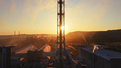 Sunset view of industrial area with tall tower and smoke rising in the Stock Footage 341028691