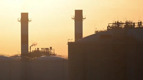 Sunset view of industrial structures with smokestacks against the sky Stock Footage 324231460