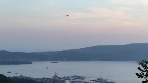 A Sunset View of Kotor Bay with a Plane Flying Overhead Stock Footage 316884361