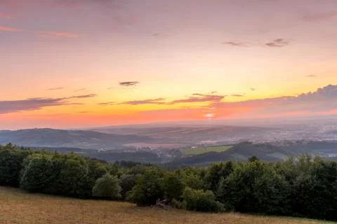 Sunset with view on landscape with fully colored clouds orange and purple and Stock-Fotos