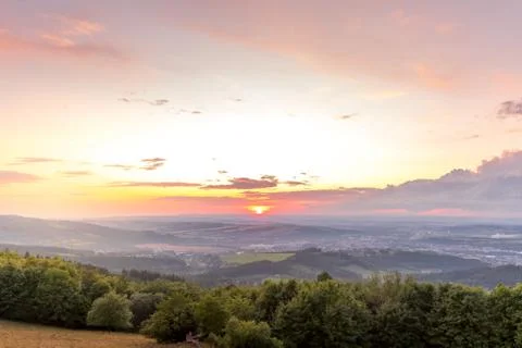 Sunset with view on landscape with fully colored clouds and orange sun goes d Foto stock