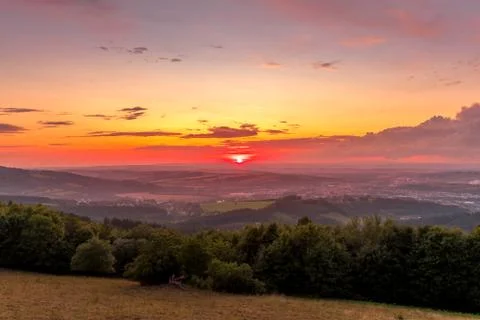 Sunset with view on landscape with fully colored clouds and orange sun goes d 写真素材