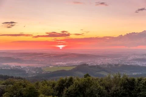 Sunset with view on landscape with fully colored clouds and orange sun goes d Stock-Fotos