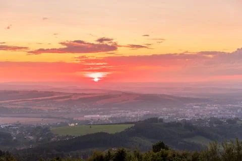 Sunset with view on landscape with fully colored clouds and orange sun goes d 스톡 사진
