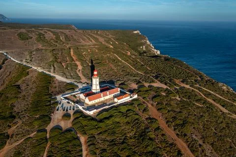 Sunset view of lighthouse and cliffs and sea of cape Espichel, Portugal Stock Photos