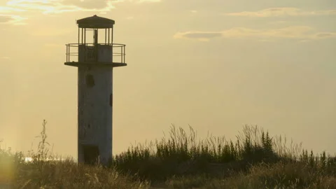 A sunset view of the lighthouse on the side of the beach Stock Footage 139688408