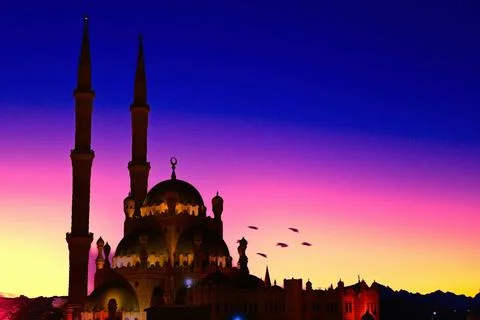 Sunset view of a mosque with two minarets and a colorful sky in the backgroun 写真素材