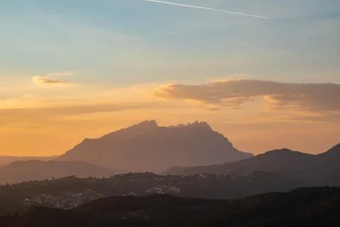 Sunset view of a mountain range with orange and blue sky Foto stock