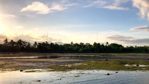 Sunset, view of the mountains from the sea at low tide, the bottom of the sea is Stockbeeldmateriaal 241581949