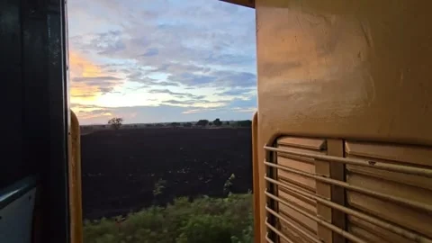 Sunset View from Moving Train Window Over Open Fields Stock Footage 321425172