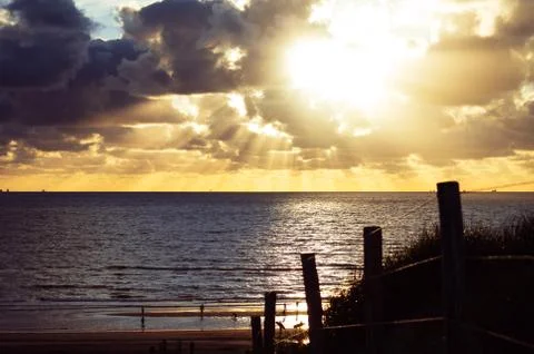 Sunset view over the beach from the top of a sand dune. Stock Photos