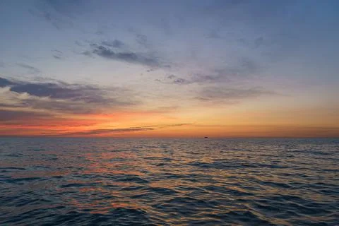 Sunset view over calm ocean waters near the coast with soft colors filling .. 库存照片