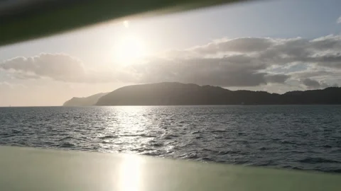 A sunset view over choppy seas from a boat with mountains in the background Stock-Footage 131247210