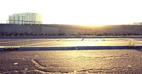 Sunset view over an empty parking lot near urban buildings Ilustración de archivo