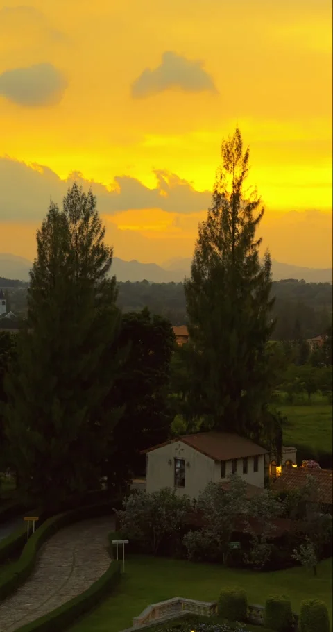 Sunset view over idyllic countryside villa, surrounded by lush Stock Footage 313817823