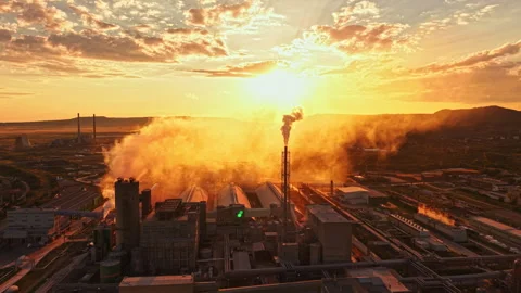 Sunset view over industrial area with smoke stacks releasing clouds during Stock Footage 341397160