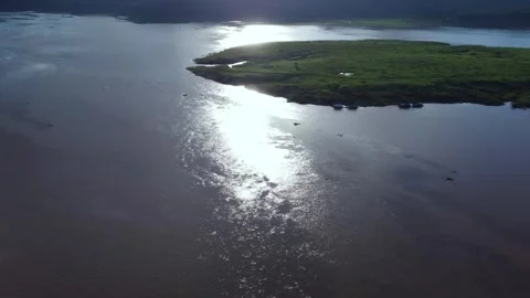 Sunset view over mountains by the lake and vast green fields under cloudy sky. 스톡 동영상 285911544