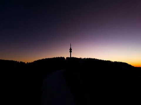 Sunset view over mountains with a tower standing on the peak and colors mix.. Fotos de archivo