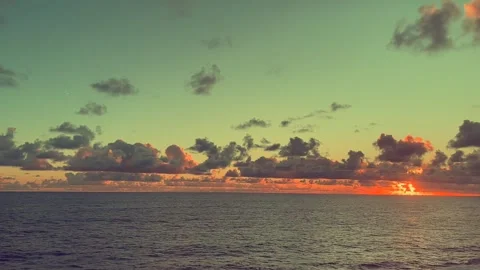 Sunset view over the ocean with clouds under a colorful sky Stock Footage 338279864