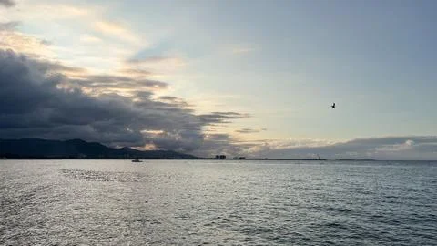 Sunset view over the ocean with the coastal city skyline and mountains Stock Photos