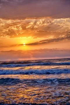 Sunset view over ocean waves with colorful sky and clouds during evening ho.. Stock Photos