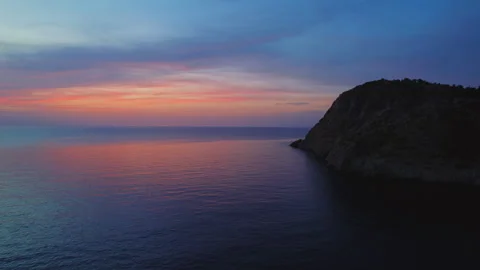 Sunset view over rocky coastline on a calm summer evening Stock Footage 344196522