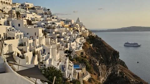 Sunset view over Santorini whitewashed cliffside overlooking the caldera with Stock Photos