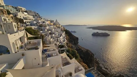 Sunset view over Santorini whitewashed cliffside overlooking the caldera with Stock Photos