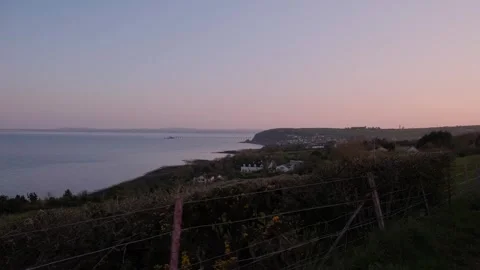 Sunset view over serene coastal landscape with distant coastal Landscape Stock Footage 306393914