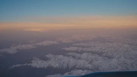 Sunset View Over Snow-Covered Mountains from Plane Stock Footage 320672630