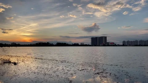 Sunset view over a wide pond with a small building placed along the horizon line Stock Footage 316700021