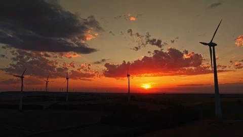 Sunset view over wind turbines in an open field during evening hours in a rural Stock Footage 344118214