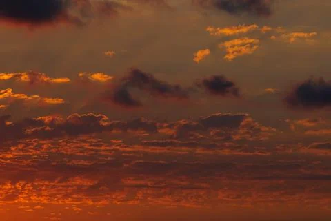 Sunset view with partly cloudy sky and sun rays. Stock Photos