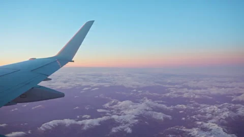 Sunset view from plane window with a plane wing on sight Stock Footage 148990916