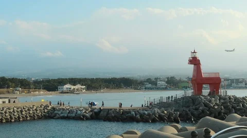 A sunset view of the sea with a red lighthouse A landmark horse-shaped lighthous Stock Footage 119509739