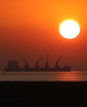 The sunset view on a seashore with a ship. Selective focus. Shallow depth of Foto stock
