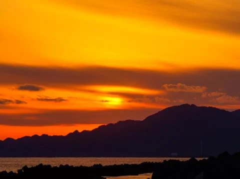 Sunset view from the shore with breakwaters Stock Photos