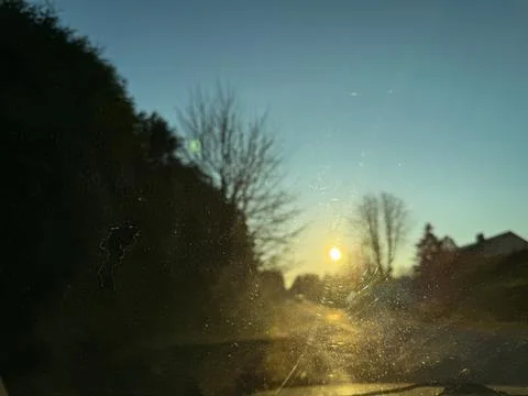 Sunset View Through Dirty Car Windshield on Rural Road Stock Photos