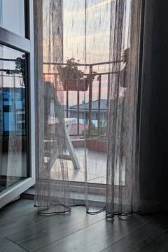 Sunset view through the light curtain in the open door to the terrace Stock Photos