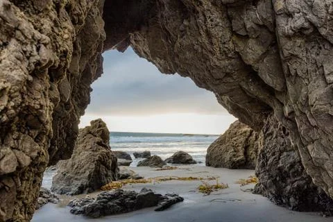 Sunset view through natural arch at Malibu beach in California Stock Photos